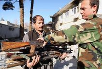 An Afghan officer carries AK-47 rifles during a handover ceremony in the Afghan capital Kabul, Dec. 23, 2009. Afghan anti-terrorism department handed over 85 AK-47 rifles and ammunition to the Disarmament of Illegal Armed Groups (DIAG) on Wednesday. The weapons were seized from illegal armed groups. (Xinhua/Zabi Tamanna)