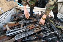 A soldier collects weapons during a handover ceremony in the Afghan capital Kabul, Dec. 23, 2009. Afghan anti-terrorism department handed over 85 AK-47 rifles and ammunition to the Disarmament of Illegal Armed Groups (DIAG) on Wednesday. The weapons were seized from illegal armed groups. (Xinhua/Zabi Tamanna)