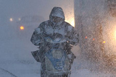 A citizen rides bicycle against wind and snow on a street in Weihai, east China&apos;s Shandong Province, Jan. 13, 2010. [Xinhua]