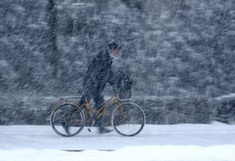 A citizen walks against wind and snow on a street in Weihai, east China&apos;s Shandong Province, Jan. 13, 2010. [Xinhua]