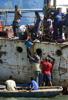 Local citizens try to flee this destroyed city by boat in Port-au-Prince, Haiti, Jan. 20, 2010. (Xinhua/David de la Pas)