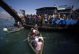 Local citizens try to flee this destroyed city by boat in Port-au-Prince, Haiti, Jan. 20, 2010. (Xinhua/David de la Pas)