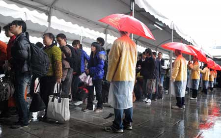 Travelers wait for their trains at Guangzhou Railway Station on Sunday.[Photo/Xinhua] 