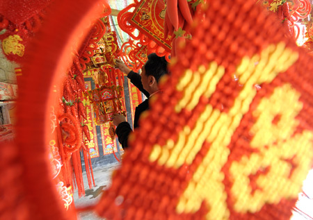  A Tibetan man chooses new year decorations at a market in Lhasa, capital of southwest China's Tibet Autonomous Region, on Feb. 8. [Xinhua Photo]