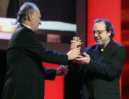 Turkish film director Semih Kaplanoglu (R) receives the Golden Bear award for Best Film for the film 'Bal' (Honey) during the awards ceremony of the 60th Berlinale International Film Festival in Berlin, Germany, Feb. 20, 2010.