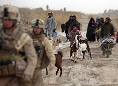 Afghans walks behind U.S. Marines from Bravo Company of the 1st Battalion, 6th Marines during an operation in Marjah, Helmand province February 21, 2010. NATO forces are facing strong resistance eight days into a major offensive in southern Afghanistan as Taliban fighters dig in to fight to the death.[Xinhua] 