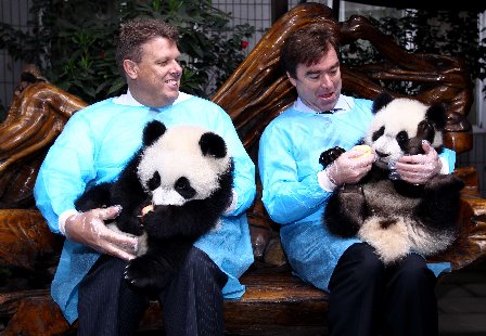 Doug Jackson (R), president of Coca Cola Greater China and South Korea, holds Mei Mei in his arms.