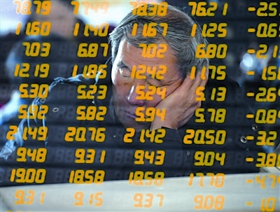 A stockholder falls asleep in a stock exchange in Shanghai on Tuesday. Chinese equities fell to six-month low Tuesday with the benchmark Shanghai Composite Index down 2.07 percent on the back of falls in energy and banking stocks. [CFP photo]