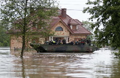 An amphibious vehicle transports people from the flooded village of Juliszew, close to Plock, central Poland, May 24, 2010.[China Daily/Agencies]