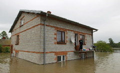  A local awaits for emergency services at his house in the flooded village of Juliszew May 24, 2010.[China Daily/Agencies]