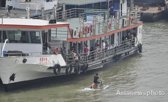 A man rides across the Hanjiang River (a tributary of the Yangtze) in Wuhan, capital of Central China&apos;s Hubei province on June 16, 2010. [Asianewsphoto] 