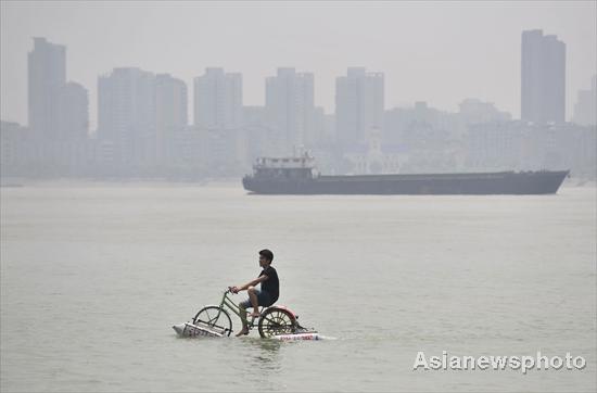 A man rides across the Hanjiang River (a tributary of the Yangtze) in Wuhan, capital of Central China&apos;s Hubei province on June 16, 2010. [Asianewsphoto] 