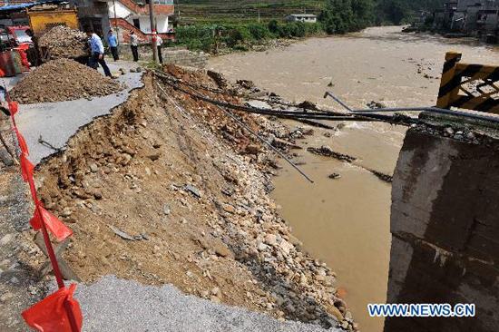 Villagers stand by a bridge broken by flood in Liaohe village in Rongshui Miao Autonomous County, southwest China's Guangxi Zhuang Autonomous Region, June 18, 2010. 