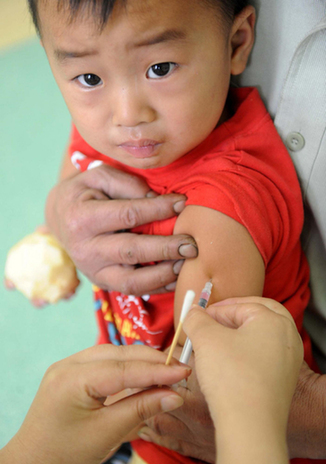 A child receives a measles vaccine from a doctor at a hospital in Qingdao, East China's Shandong province on Sept 11, 2010. The nationwide measles vaccination, targeting nearly 100 million children in the age bracket from 8 months to 4 years, starts from Saturday and it will last till Sept 20. [Photo/Xinhua]