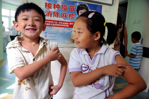 Children react after receiving measles vaccines at a hospital in Qingdao, East China's Shandong province on Sept 11, 2010. [Photo/Xinhua] 