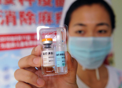 A doctor shows a sample of the measles vaccine at a hospital in Qingdao, East China's Shandong province on Sept 11, 2010. [Photo/Xinhua] 