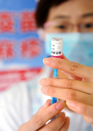 A doctor prepares to inoculate a child at a hospital in Qingdao, East China's Shandong province on Sept 11, 2010. [Photo/Xinhua]