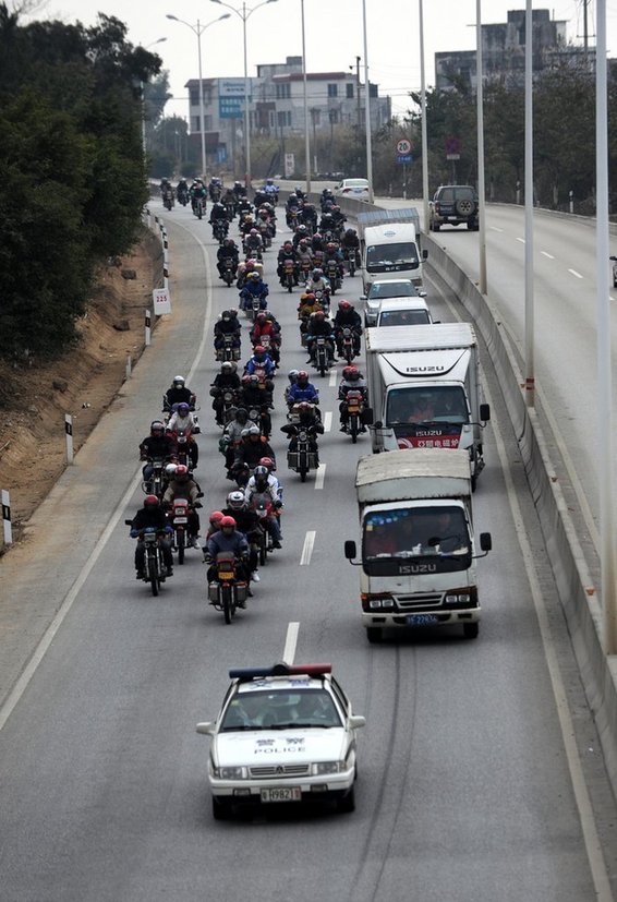 A photo taken on Jan 27 2011 in Zhaoqing City, Guangdon Province shows a group of migrant workers ride motorcycles back to their hometown for Spring Festival. [Photo/Sina]