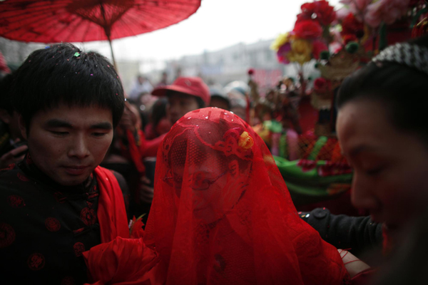 Rebecca Kanthor (C) and Liu Jian (L) arrive to their traditional Chinese wedding in Dong&apos;an at the central province of Henan, February 9, 2011. [China Daily/Agencies]