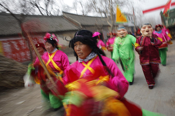 Local residents perform wearing costumes during a traditional Chinese wedding in Dong&apos;an at the central province of Henan, February 9, 2011. [China Daily/Agencies]