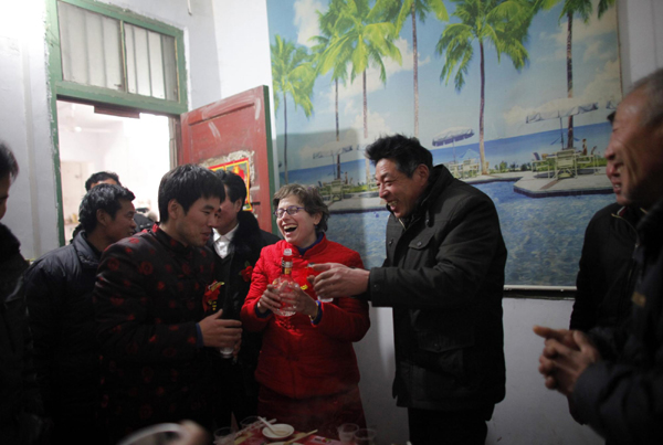 Liu Jian (L) and his wife Rebecca Kanthor celebrate with relatives after their traditional Chinese wedding in Dong&apos;an at the central province of Henan, February 9, 2011. [China Daily/Agencies]