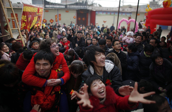 Liu Jian (L) carries his wife Rebecca Kanthor after their traditional Chinese wedding in Dong&apos;an at the central province of Henan, February 9, 2011. [China Daily/Agencies] 