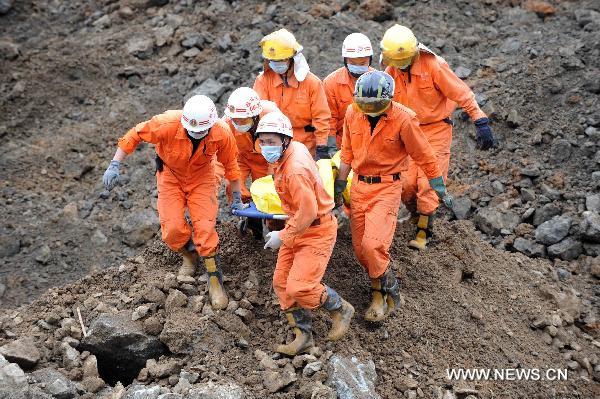 Rescuers carry the body of a landslide victim in the village of Luojiang, south China's Guangxi Zhuang Autonomous Region, May 10, 2011. The death toll rose to 7 as of 3 p.m. on Tuesday while 15 quarry workers remained missing after a landslide roared down rain-saturated hills and engulfed a makeshift dormitory in Luojiang at 1:30 p.m. on Monday. One survived the disaster. [Xinhua/Zhou Hua]