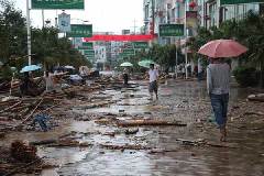 Local residents walk on a street in Wangmo county, Southwest China's Guizhou province, after the floods on June 6, 2011. [Photo/Xinhua]