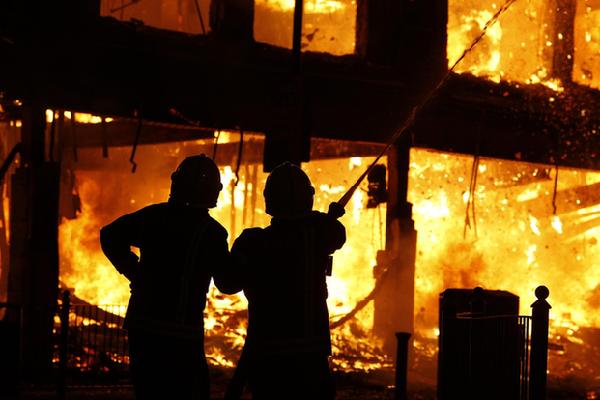 Firefighters tackle a fire in a building in Tottenham, north London August 7, 2011. Crowds attacked riot police and set two squad cars alight in north London on Saturday following a protest at the fatal shooting of a man by armed officers earlier in the week. [Agencies]