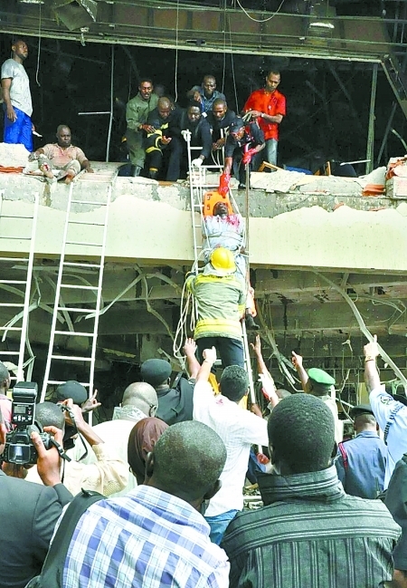 Rescue workers help an injured person out of the UN building in Nigeria's capital Abuja on August 26, 2011. 