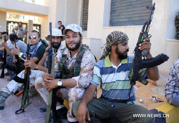 Libyan rebels rest in the market area of Tripoli, Libya, Aug. 29, 2011. Muammar Gaddafi is still a threat to Libya and the world, as his whereabouts remain misty, chief of the executive board of the Libyan National Transitional Council (NTC) Mostafa Abdel Jalil said Monday. [Hamza Turkia/Xinhua] 