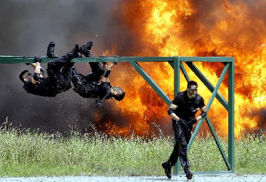 Photo taken on Sept 14, 2011 shows regimental police in an obstacle race of an anti-terror drill in Shanghai. The special police corps of Shanghai Public Security Bureau practiced the quick response ability to terrorist attacks and emergencies in the one-hour drill. [Xinhua/Fan Jun]