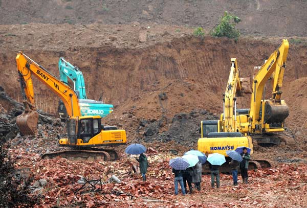 Excavators work during a rescue operation at the site where a landslide occurred in Baqiao District of Xi'an, capital of northwest China's Shaanxi province, Sept. 18, 2011. The landslide was triggered on Saturday afternoon by a heavy rainfall. [Photo/Xinhua]