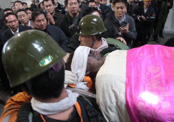 A trapped miner is rescued on Friday a day after a rock burst in Qianqiu Coal Mine, Henan Province. The accident stranded 75 miners in the shaft and killed at least eight out of them. [CFP]