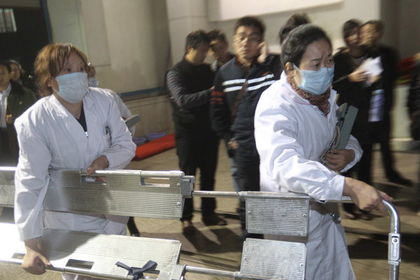 Nurses carrying a stretcher rush to the scene where at least 14 out of the 75 miners trapped by a rock burst in Qianqiu Coal Mine, Henan Province were pulled out of the collapsed shaft on November 4, a day after the accident. Eight people were confirmed dead on Saturday morning and the rescue is still in the process. [CFP]