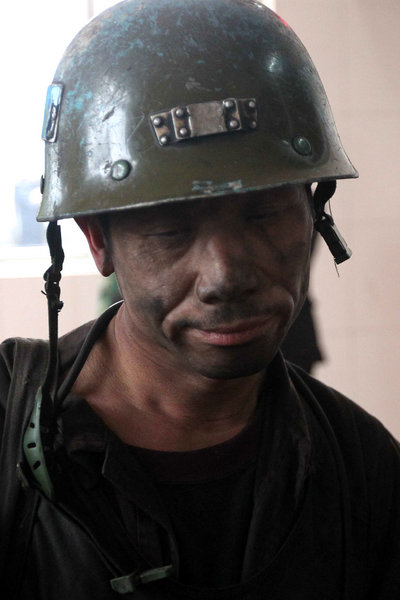 A rescuer returns from the collapsed shaft in Qianqiu Coal Mine, Henan Province. A rock burst there on November 3 stranded 75 working miners and killed at least eight out of them. [CFP]