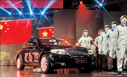 Workers from FAW Group sing around the Red Flag H7 premium sedan during a ceremony to mark the start of mass production of the new model yesterday in Changchun, Jilin Province. FAW hopes to revive its Red Flag brand, one of China's two oldest car brands and a former favorite of Chinese leaders. 