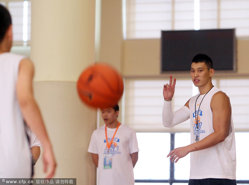 Jeremy Lin is giving instructions to kids at the opening day of J-Lin Basketball Camp 2012 in Dongguan, Guangdong Province on August 19, 2012.