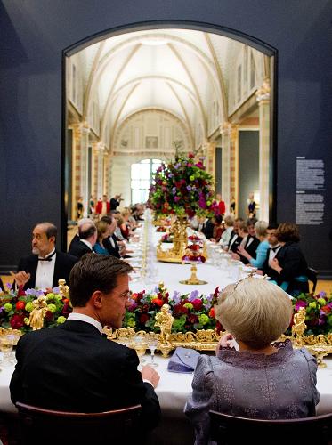 Queen Beatrix of the Netherlands talks on April 29, 2013 with Dutch Prime Minister Mark Rutte while hosting a dinner at the National Museum (Rijksmuseum) in Amsterdam on the eve of her abdication. [Xinhua/AFP]