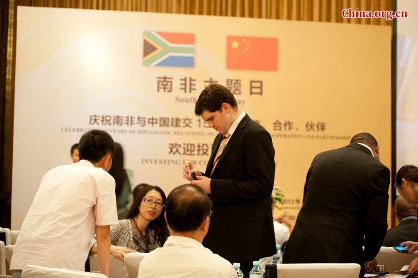 Attendants, both from China and South Africa, to the South African Day exchange contact information prior to the beginning of the event. [Photo / Chen Boyuan]