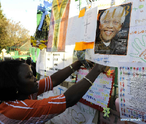 A local resident pastes a card on a wishing board outside the hospital where South Africa's anti-apartheid icon Nelson Mandela is treated in Pretoria, South Africa, to pray for Mandela, June 26, 2013. 