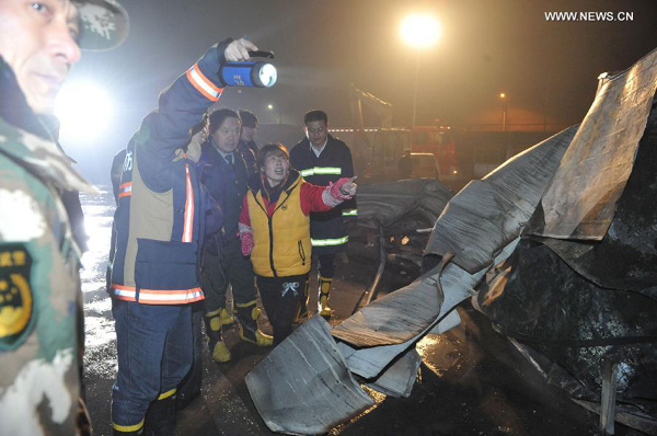 Rescuers work at the accident site after a carrot packaging workshop of Longyuan Food Co., Ltd caught fire in Shouguang City, east China's Shandong Province, Nov. 17, 2014. At least 18 people died and 13 others injured in the fire which broke out on Sunday evening