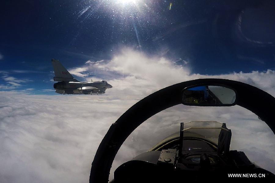 A video frame grab taken on Aug. 27, 2015 shows a new type of jet fighter flying over clouds during a drill in the East China Sea.